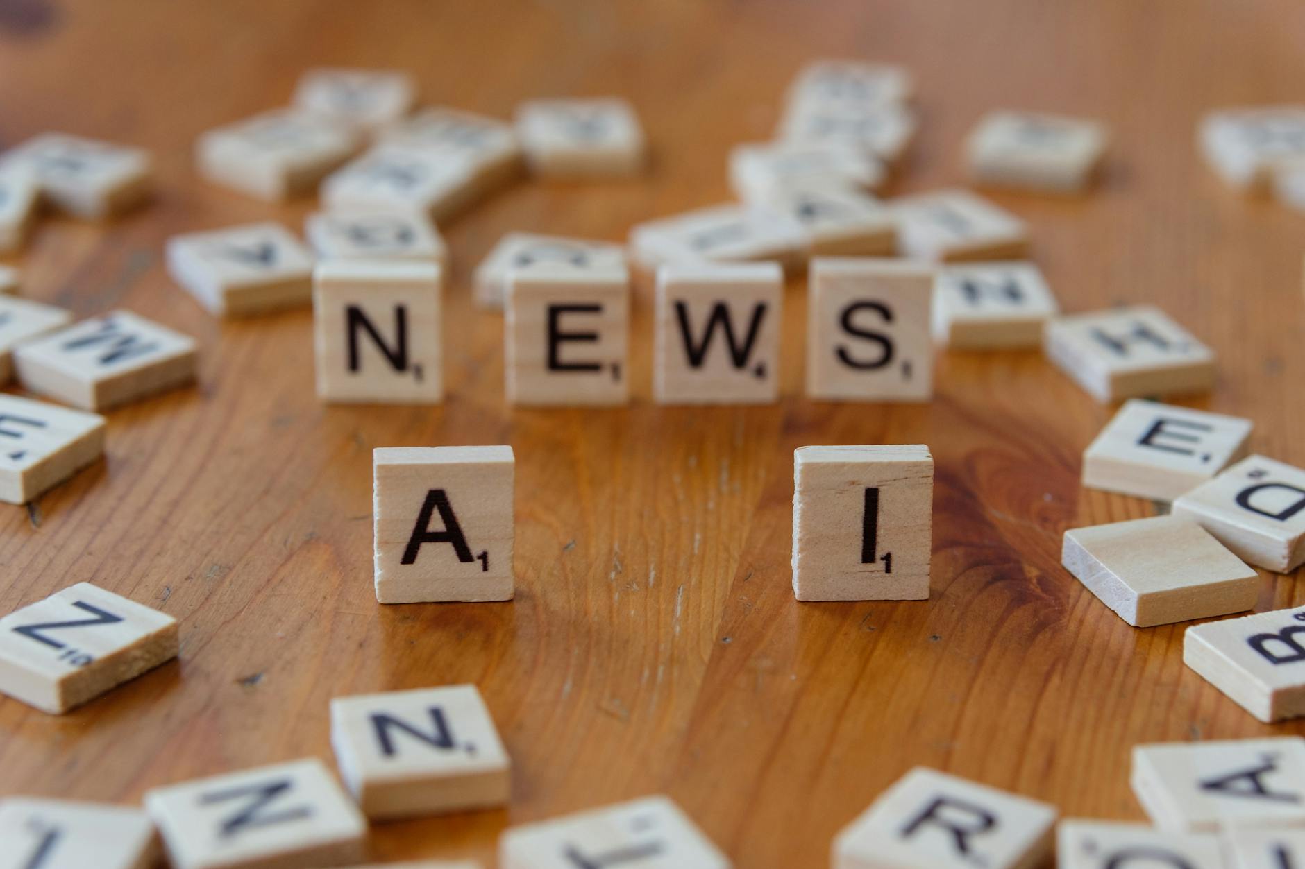 Drewniane kafelki Scrabble układające się w napisy AI i NEWS
