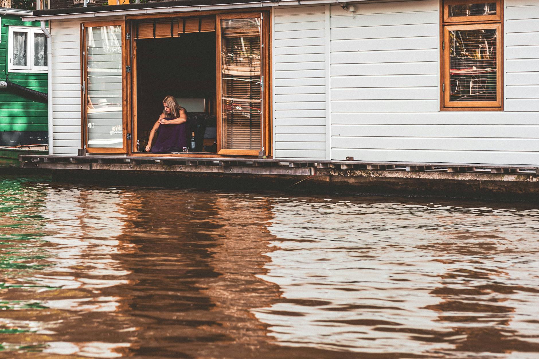Kobieta relaksuje na houseboacie na kanale w Amsterdamie