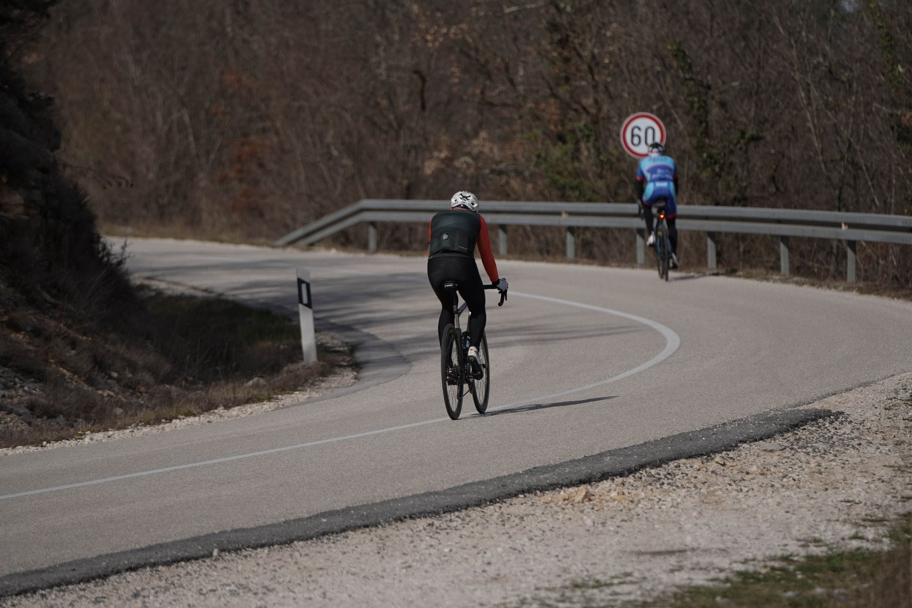 Dwóch rowerzystów podjeżdża pod górę krętą szosą w Chorwacji