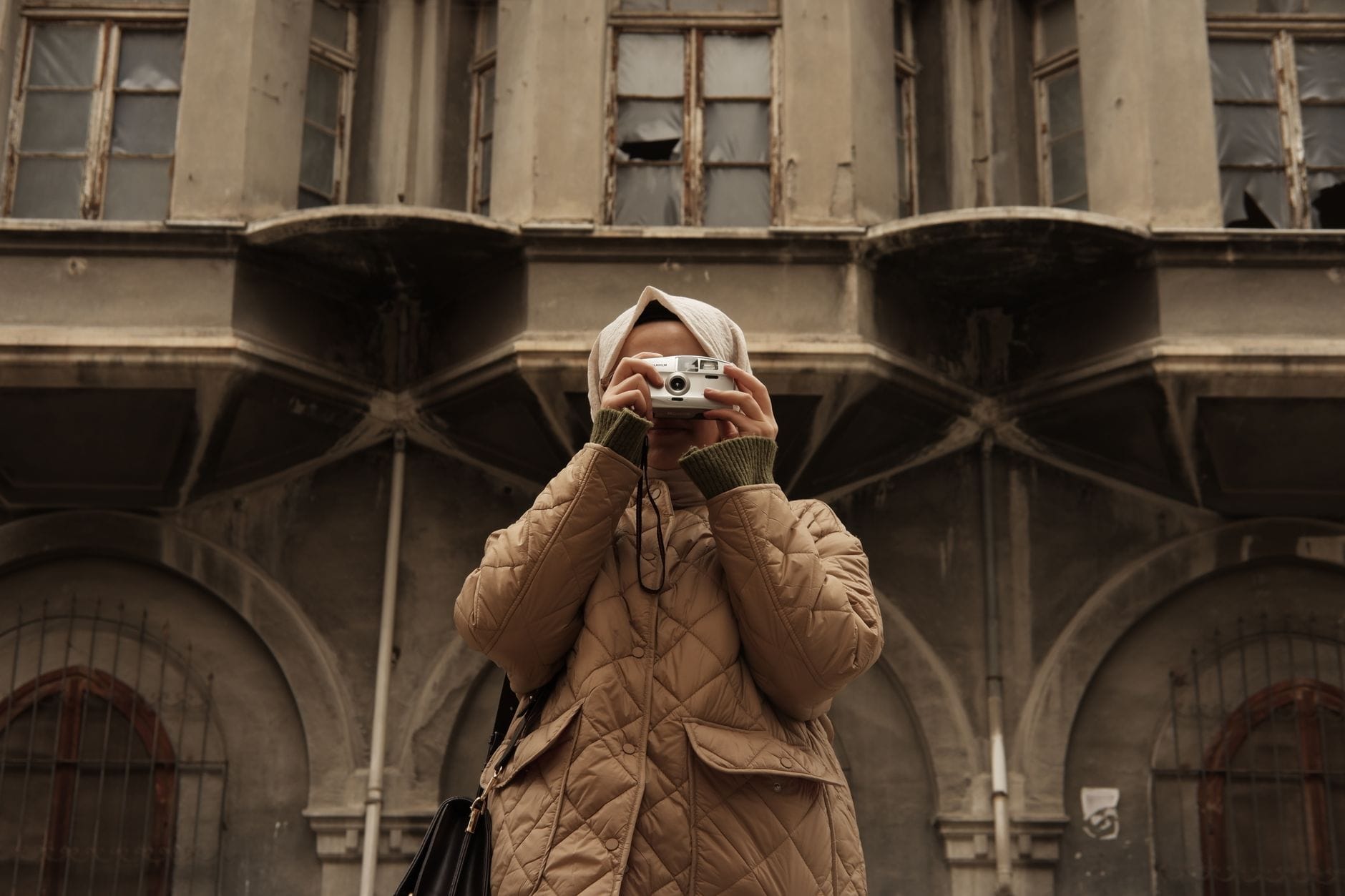 Kobieta fotografuje zabytkową kamienicę w centrum Lwowa