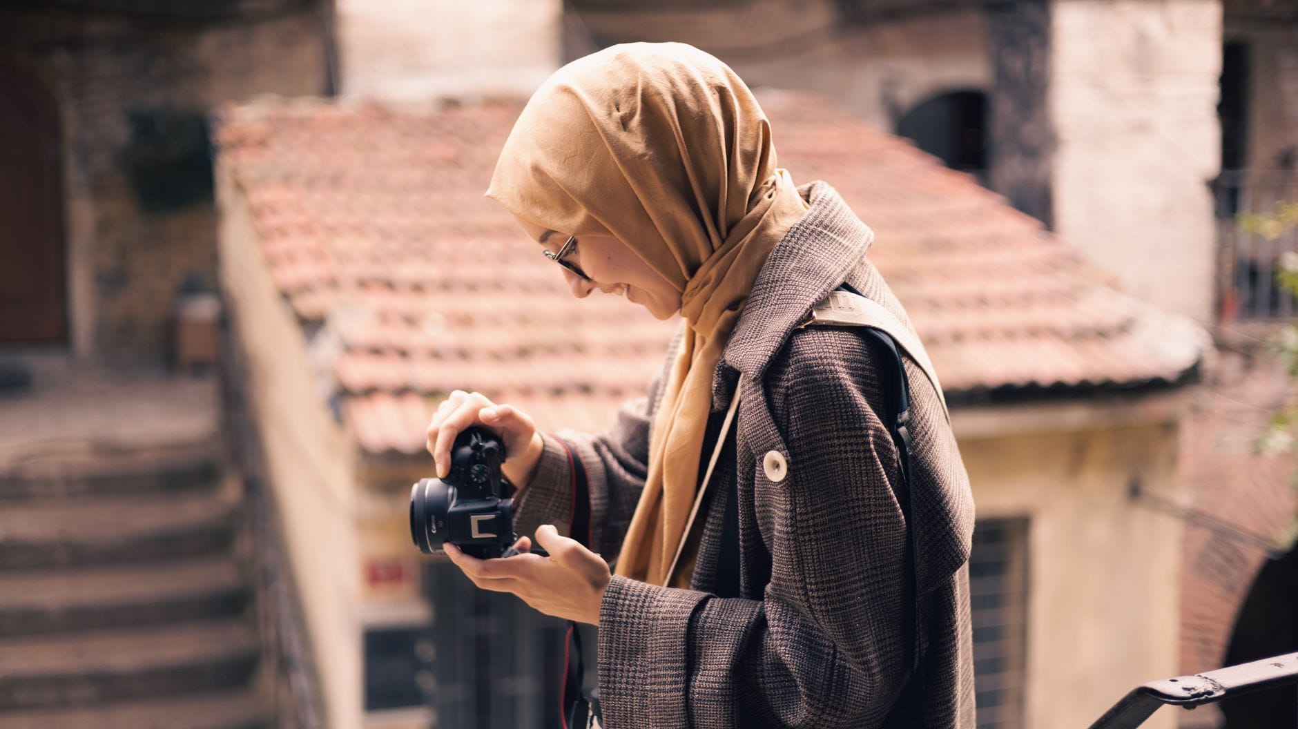 Kobieta w hidżabie fotografuje miasto z ulicy